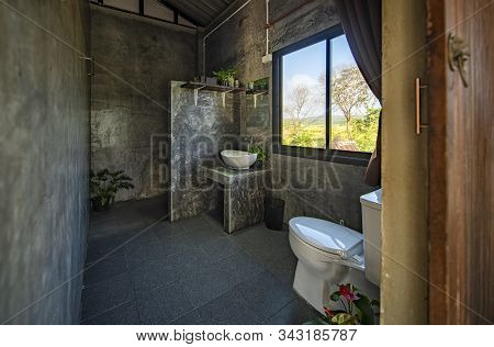 Modern Toilet Room With Concrete Wall, Wooded Door And Windows In Home Stay In Pua, Nan, Thailand