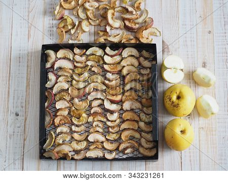 Sliced Apples Are Dried On A Metal Wire Rack From A Home Dryer. Wooden White Rustic Table.