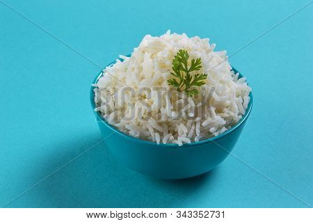 Cooked Plain White Basmati Rice With Corriander In A Blue Bowl On Blue Background