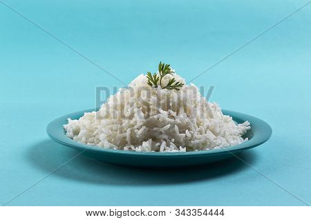 Cooked Plain White Basmati Rice With Corriander In A Blue Plate On Blue Background