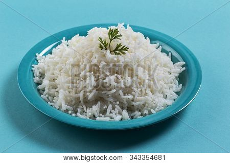 Cooked Plain White Basmati Rice With Corriander In A Blue Plate On Blue Background