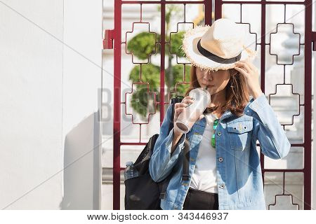 Beautiful Charming Asian Woman In White T-shirt With Jean Jacket Drinking Cocolate Milk With Straw U