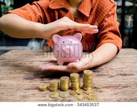 Business Woman Hand Prevent  Pink Piggy Bank With 
Gold Coins Pile Growth Graph, Saving Money For Fu