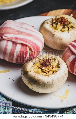 Preparing Of Bacon-wrapped Button Mushrooms Stuffed With Grated Cheddar Cheese And Spices