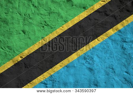 Tanzania Flag Depicted In Bright Paint Colors On Old Relief Plastering Wall. Textured Banner On Roug