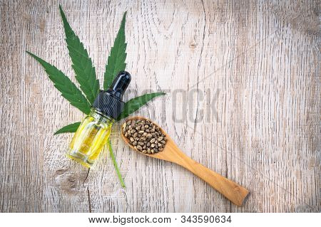 Hemp Seeds And Hemp Oil On Brown Wooden Table. Cbd Hemp Oil.