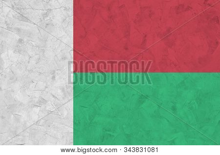 Madagascar Flag Depicted In Bright Paint Colors On Old Relief Plastering Wall. Textured Banner On Ro