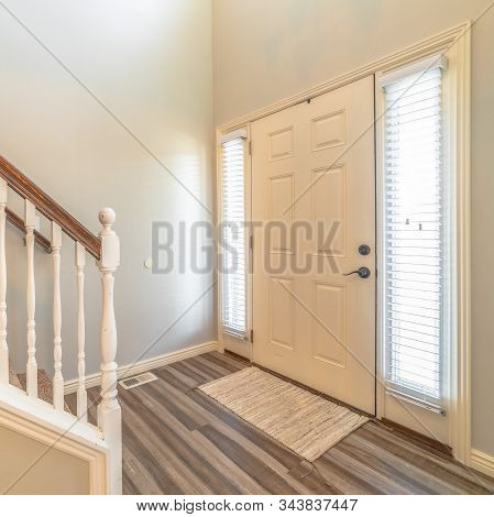 Square Home Interior With Stairs In Front Of The White Front Door Flanked By Sidelights