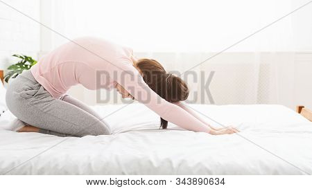 Yoga Practice. Active Young Woman Exercising Child Pose On Bed At Home, Panorama, Free Space