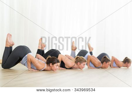 Group Of Young Sporty Sexy Women In Yoga Studio, Practicing Yoga Lesson With Instructor, Forming A L