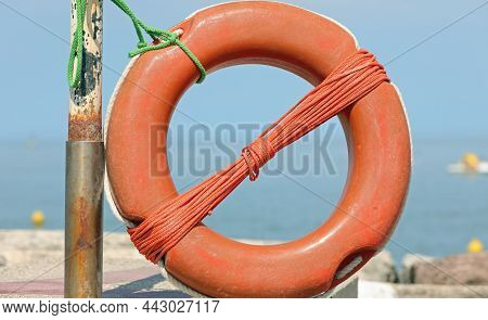 Large Orange Lifebuoy Available To Swimmers On The Ocean Shore