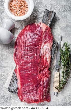 Fresh Flank Or Flap Raw Beef Steak On Wooden Board With Herbs. Gray Background. Top View