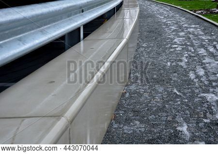 Retaining Seat Wall Made Of Pure Cast Concrete. There Are Road Barriers As A Backrest. Trowel Paveme