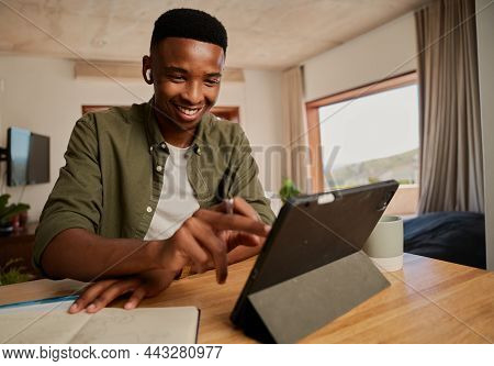 Happy Young Adult Black Male Typing On Electronic Tablet While Wearing Earphones. Remote Working Fro