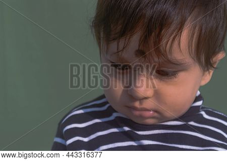 Beautiful Cute Sad Looking Baby In Chin Down Posture. Bored Face, Lonely Boy Leaning His Head Down I