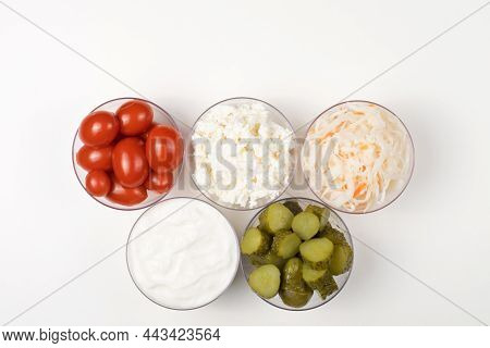 A variety of fermented foods for gut health. Bowls on a white background. Cucumbers, tomatoes, sauer