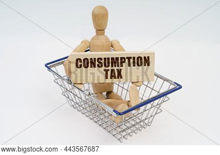 Business And Finance Concept. A Wooden Man Sits In A Shopping Basket, Holding A Sign In His Hands - 