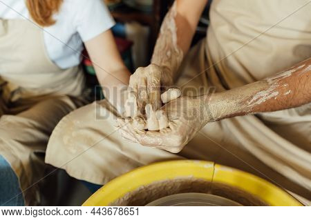 A Couple In Love Creates A Joint Cup In A Pottery Workshop. Potter Making Ceramic Pot On The Pottery