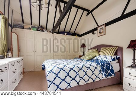 Stradishall, Suffolk, England - June 4 2020: Bedroom In British Cottage With Vaulted Ceiling Reveali