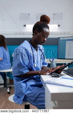 African American Woman Nurse Checking Sickness Expertise Using Tablet Computer Working In Hospital O