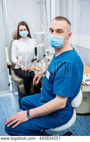 Ophthalmologist Consultation In A Modern New Hospital. A Modern Doctor Working With The Patient's He