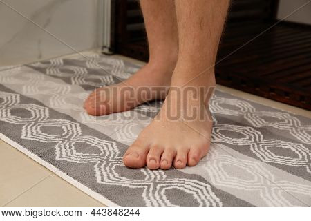 Man Standing On Stylish Mat Near Shower Stall In Bathroom, Closeup