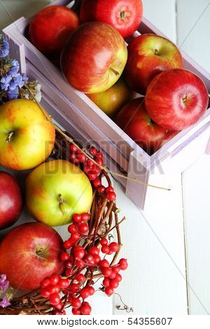 Juicy apples in box on white wooden table