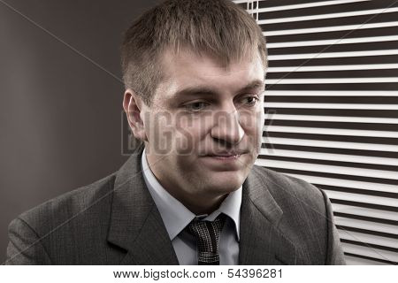 Frustrated young office worker looking down wearily
