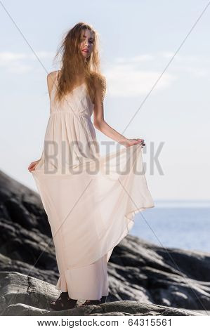 Young Woman On Rocky Shore
