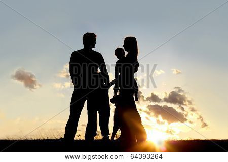 Silhouette Of Happy Family And Dog Outside At Sunset