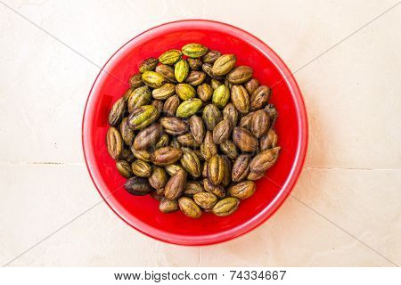 Dried Yellow Mayrobalan kept in a container on an isolated background