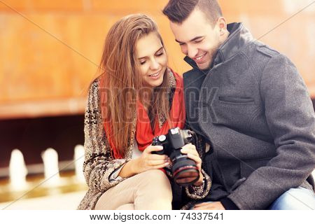 A picture of a young couple checking pictures on their camera