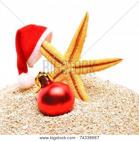 Starfish, Christmas Buable And Santa Claus Hat On The Sand