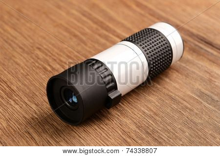 Modern monocular on wooden background