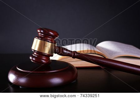 Judge's gavel and open book on dark grey background