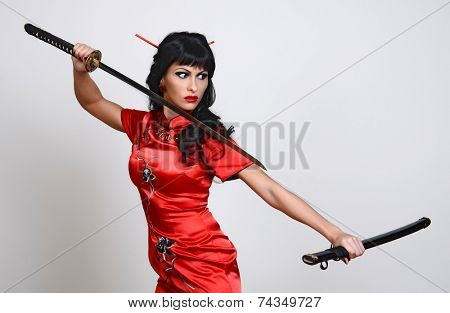 Beautiful geisha in kimono with samurai sword