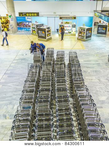 Passengers Pick Up The Baggage Cart At The Central Point At The Airport