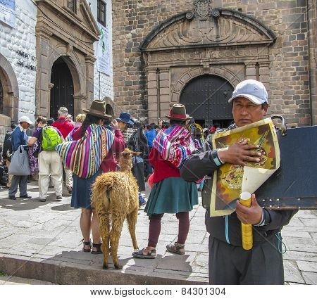 Indian Woman Pose With A Lama For Tourists In Cuzco,man Sells Paintings