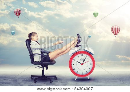 Woman in jacket and skirt sitting on chair. Background of clouds, hot air balloon