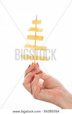 Female hand holding French fries on a stick in white background