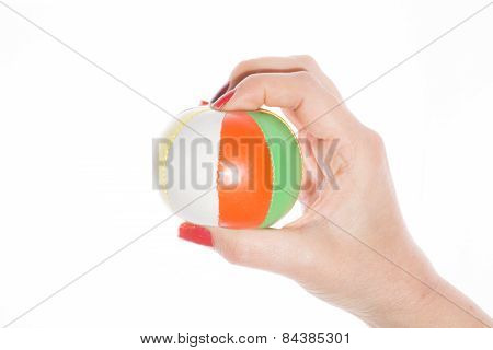 female hand holding colored juggling balls on a white background