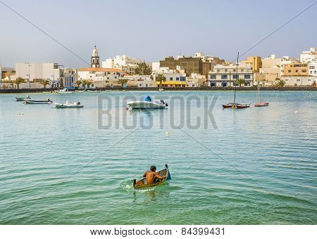 Boy Paddles With His Small Canoe