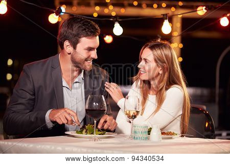 Couple eating dinner at rooftop restuarant