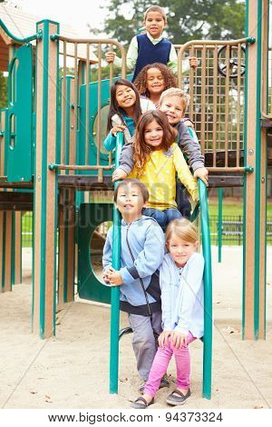 Young Children Sitting On Climbing Frame In Playground