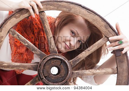 young woman with an old wagon wheel on white background