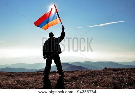 Man holding Armenian flag on a mountain peak