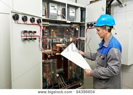 electrician builder engineer inspector checking data of equipment in fuse box