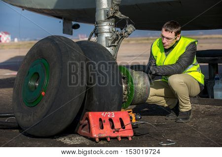 Male mechanic fixing airplane's wheels at airport