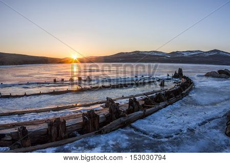 At Dawn Skeleton Of A Ship Frozen In The Ice On The Shore