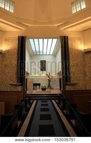Wooden casket with funeral flowers in a crematorium hall